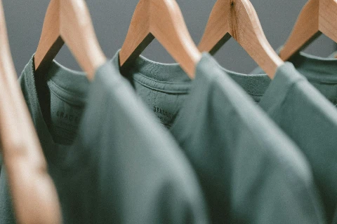 Grüne T-Shirts auf Holzbügeln